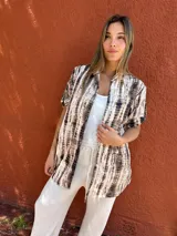 Camisa marrón con estampado abstracto en tonos marrones y blancos, de corte holgado y mangas cortas.