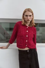 Chaqueta roja de tweed con cuello redondo, manga francesa, bolsillos delanteros y cierre frontal con botones dorados.