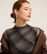 Blusa de tul de manga larga con cuello alto y estampado de cuadros escoceses en tonos marrones, azules y grises.