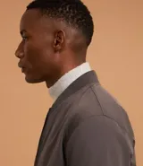 Campera bomber de poliéster color gris oscuro, con cuello alto, cierre frontal con cremallera, bolsillos laterales, mangas largas con puños ajustados y bajo con ajuste elástico.