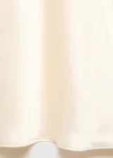 Falda maxi color crema de tejido satinado con goma elástica en la cintura y abertura lateral.