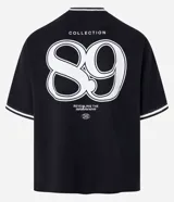 Remera deportiva negra de manga corta con cuello redondo y estampa frontal en relieve con la frase "Alternate Dept Collection Revealing the unknown Powered by Dreamerland".
