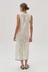 Vestido midi tejido de punto color crudo, con calados florales, calce recto, tajos laterales y detalles en celeste en cuello, sisas y ruedo.