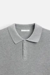Polo marrón de punto con hilatura de algodón, corte relaxed fit, cuello solapa con cierre frontal de botonadura, manga larga y acabados en rib.