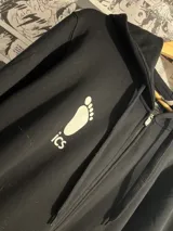 Campera negra con capucha y cierre frontal, con estampado en la espalda de texto en japonés en color blanco. Diseño inspirado en el anime Haikyu!!