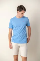 Remera celeste de manga corta con bolsillo en el pecho y logo bordado en color fucsia.