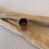 Anillo ancho de bronce color dorado con una piedra cuadrada color gris.