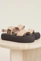 Sandalias con plataforma color beige, con dos tiras anchas sobre el empeine y tira con hebilla alrededor del tobillo.