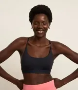 Top deportivo negro confeccionado en microfibra sin estampa, con espalda abierta y breteles finos cruzados.