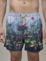 Short de baño con estampado de flores y hojas en tonos verde, rosa y amarillo. Tiene cintura elástica con cordón ajustable y forro interior de malla.