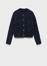 Chaqueta color celeste de tejido bouclé con cuello redondo, cierre frontal con botones efecto joya, dos bolsillos de parche frontales y mangas largas.
