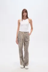 Pantalón de algodón con estampado de leopardo en tonos grises y beige. Diseño recto con cintura elástica ajustable con cordón beige y franja lateral lisa en color beige.