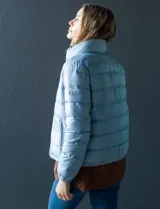 Campera puffer reversible Michael Kors color rosa con estampado de logos MK en un lado y liso en el otro. Tiene cierre central metálico, bolsillos delanteros y avíos metálicos con logo. Incluye bolsa autoportante.