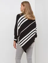 Poncho de tejido color beige con cuello alto y rayas diagonales anchas en azul marino. Presenta mangas largas y terminación asimétrica.