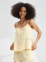 Musculosa color amarillo pálido con tirantes finos y detalle de lazo en el escote.