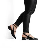Zapato de vestir negro charol con punta fina, dos tiras finas sobre el empeine y taco bajo cuadrado.