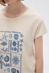 Remera color crema con estampado de motivos playeros en color azul.