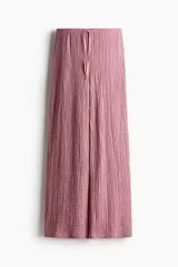 Pantalón recto color rosado, de punto con efecto arrugado, con elástico y cordón ajustable en la cintura.
