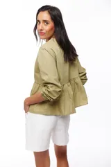 Blusa color verde oliva con escote en V, mangas largas abullonadas con puños elásticos y detalle de calado en hombros y cintura.