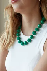 Collar de cuentas esféricas grandes de acrílico blanco, ensartadas en un cordón claro.