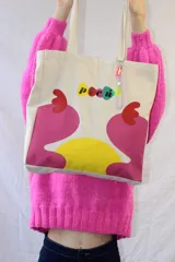 Bolso tipo tote de lona color crudo con asas de tela. Estampado con el logo 'picú' y diseño abstracto en colores amarillo, verde y fucsia.
