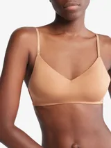 Corpiño color piel de Calvin Klein, con breteles finos ajustables con logo de la marca, escote en V y copas con relleno ligero sin aro.