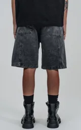 Bermuda de denim negro con efecto lavado, calce oversize, estilo cargo y múltiples bolsillos.