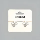 Aros plateados con forma de flor con pétalos blancos y centro brillante.