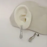 Aros colgantes plateados con forma de gota irregular.