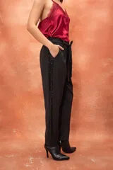 Pantalón de vestir gris con cintura elástica en la parte trasera, corte recto y franja lateral de lentejuelas negras.