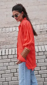 Camisa color naranja de lino con mangas abuchonadas y detalle calado en los puños.