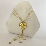 Collar dorado con cadena fina y dije grande en forma de corazón irregular, con tres dijes pequeños de corazón colgando.