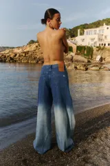 Pantalón de jean de tiro medio, corte oversize y efecto degradado suave.