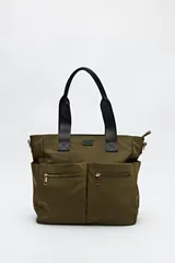 Bolso tote color verde militar, confeccionado en nylon, con doble asa de mano negra y correa larga regulable y desmontable. Tiene dos bolsillos frontales con cierre metálico dorado.