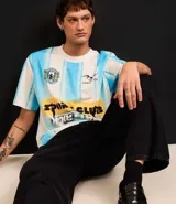 Remera masculina de poliéster con estampa de rayas verticales en celeste y blanco, escudo y lettering "Sport Club Hat Trick".