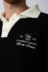 Sweater de punto verde con cuello polo color crema y bordado frontal con texto en blanco.