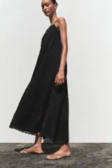 Vestido midi negro de tirantes finos con escote recto y detalle de bordados perforados a tono.