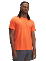 Remera deportiva Under Armour Launch color naranja con logo reflectivo en el pecho.