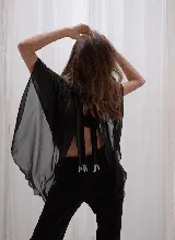 Capa corta color verde esmeralda de gasa transparente, con cuello redondo y abertura frontal con cierre de botón.