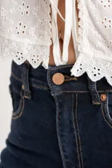 Jean de mezclilla azul oscuro, tiro medio, con corte acampanado (flare) y pierna ancha.