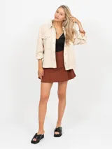 Falda short de tiro alto, color marrón óxido, con cierre lateral oculto.