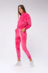Conjunto deportivo de terciopelo fucsia, compuesto por un buzo de cuello alto y un pantalón jogger con bolsillos laterales.