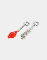 Set de dos charms intercambiables con diseño asimétrico: uno con forma de labios rojos y otro con forma de zapatillas de ballet plateadas con moño.