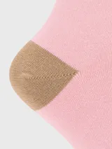 Calcetín de mujer color rosado, largo medio, con puntera y talón en color marrón. Presenta un bordado de perro de raza Basset Hound en la caña.