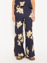 Pantalón de punto azul marino con estampado de flores blancas y marrones, cintura elastizada y corte amplio en las piernas.