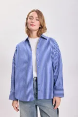 Camisa celeste con rayas verticales blancas, de corte holgado y mangas largas.