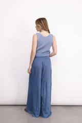 Pantalón ancho de lino color vino, con tiro medio y elástico en la cintura. Presenta una pierna ancha tipo elefante con un refajo inferior para mejorar la caída.