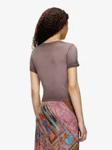 Remera ajustada de manga corta, color blanco hueso, con cuello redondo. Presenta un estampado central de un corazón rojo con el logo de Diesel en su interior.