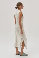 Vestido midi tejido de punto color crudo, con calados florales, calce recto, tajos laterales y detalles en celeste en cuello, sisas y ruedo.