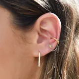 Par de aros tipo cuff dorados con diseño trenzado y bolitas en los extremos.